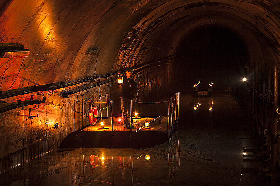 Illuminated flooded tunnel inside Galleria Borbonica in Naples